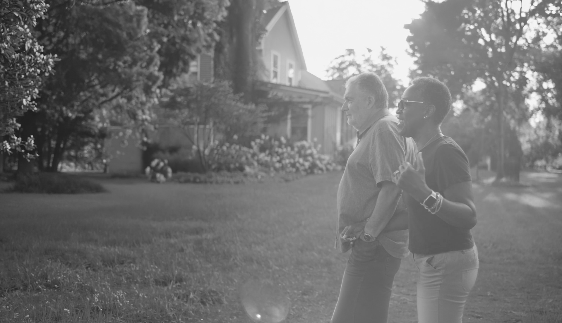 Chris and Carlene Ellerman walking together hand in hand along a tree-lined path